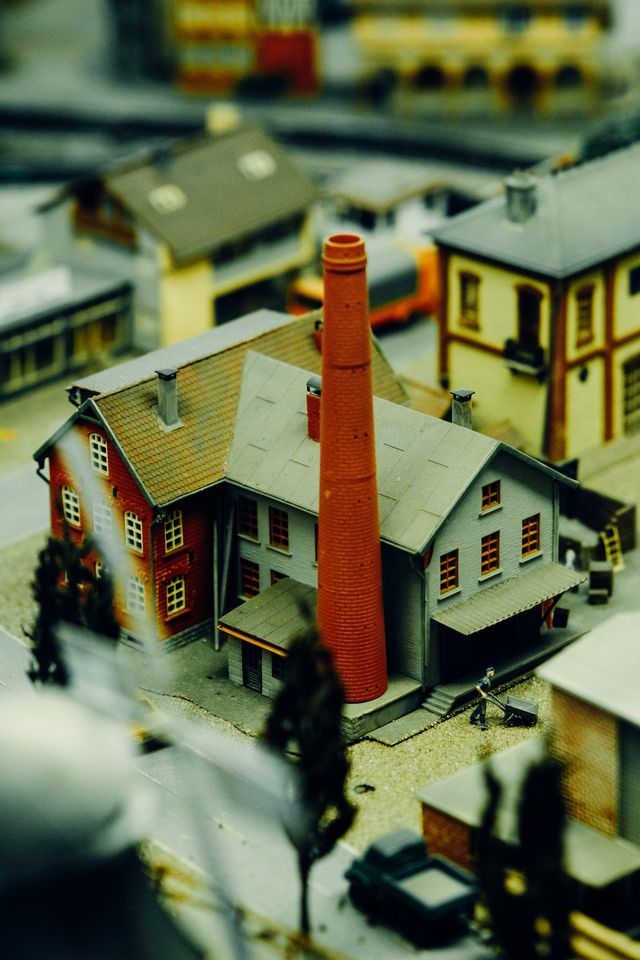 Detailed miniature model of an urban industrial setting with a chimney and buildings vividly captured.